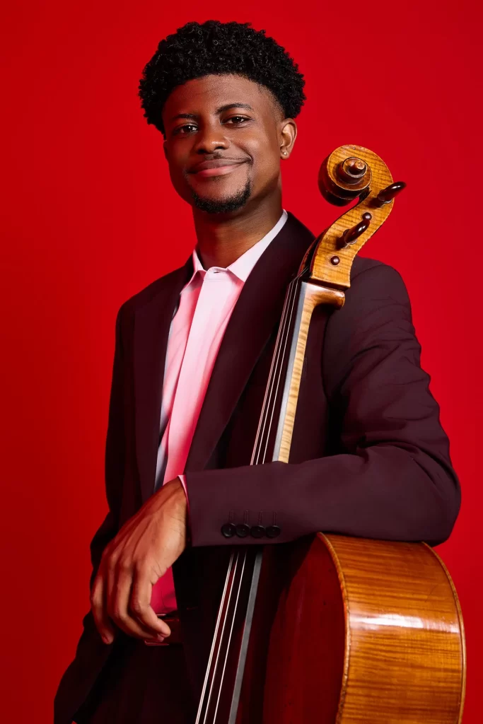 Sterling Elliott with his arm draped around a cello